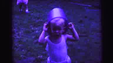 Lynbrook New York (1971): Boy Wearing White Shirt Puts Blue Bucket On Top Of Head