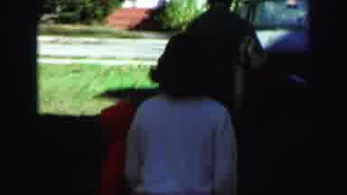 Lynbrook New York (1971): Woman Wearing Brown Dress Soothes Crying Baby Wearing