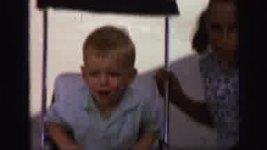 Lynbrook New York-1971: Two Siblings Interact With Crying Toddler In Stroller On Sunny Day