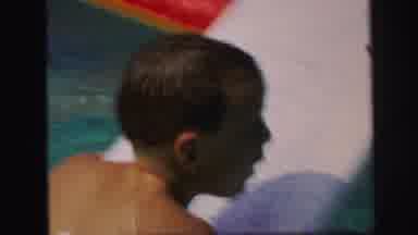 Lynbrook New York (1971): Youngster In Pool Makes For The Edge While Floating On