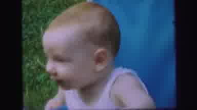 Lynbrook New York (1971): Baby Is Waving Hi At The Camera While He Is Sitting On A