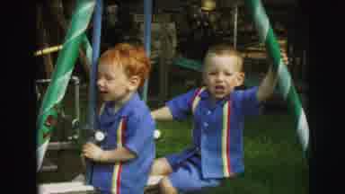Lynbrook New York (1973): Two Young Boys Wearing Matching Outfits Sitting On A