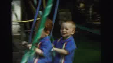 Lynbrook New York (1973): Pair Of Boys Wearing Blue Shirt Play On Green Swing Set