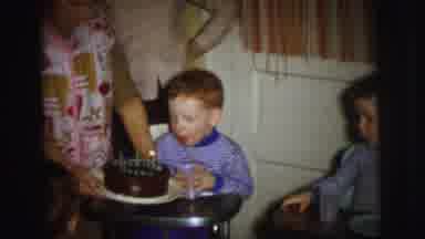 Lynbrook New York (1973): Woman Holding Cake In Front Of Boy Blowing Out Three