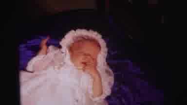 Lynbrook New York (1973): Baby Wearing White Christening Gown Lays On A Blue