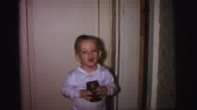 Lynbrook New York (1973): A Young Child Smiling While Looking Around While Holding