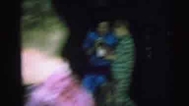 Lynbrook New York (1973): Girl Wearing Pink Robe Walks Past Lit Trimmed Christmas