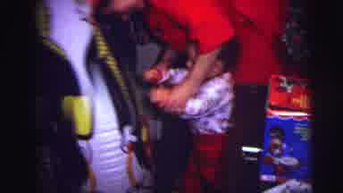 LYNBROOK NEW YORK-1973: Woman in Red Robe Helps Baby Play With Inflatable Clown