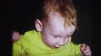 Lynbrook New York (1973): Baby Wearing Green Shirt Walks Toward White Floor Stool