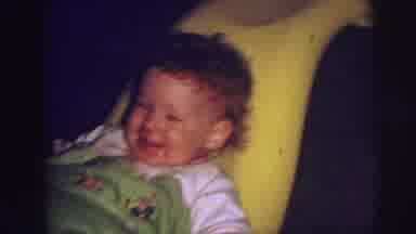 Lynbrook New York (1973): Baby Wearing Green Pants Sits In A Bright Yellow Chair