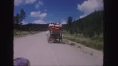 Colorado (1958): Horse Drawn Carriage Filled With People Travels Down Dirt Road In