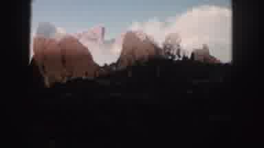 Colorado (1958): People Riding Down A Street Surrounded By Mountains