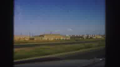 Colorado (1958): Drive By View On A Road Of A Lot Of Factory Buildings Off In The