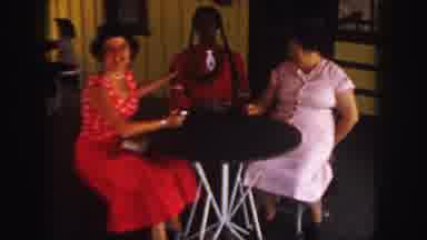 Colorado (1958): Two Women Sitting At Table Next To Life-Size Doll In Red Dress