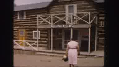 Colorado (1958): Woman In Dress Walking Across Dirt To Porch Of Log Cabin Cafe