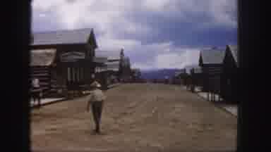 Colorado (1958): People Walking Across A Dirt Road In The Middle Of A Old Western