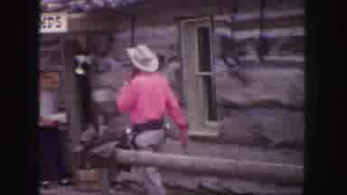 This cowboy's pink shirt is more threatening than his dual guns