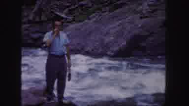 Colorado (1958): Man Standing By Fast Moving River Smoking A Cigarette