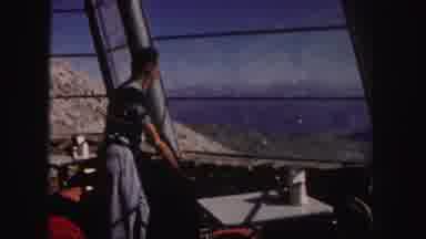Colorado USA (1958): Man Stands And Leans Against Desk And Looks Out Window At The