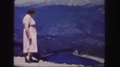 Colorado USA (1958): Woman Stands On A Mountain And Points To Lake And Valley