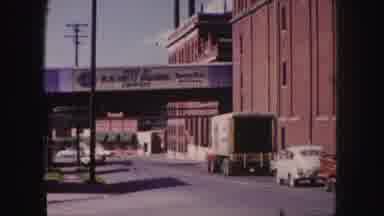 Denver Colorado (1958): White Car And Truck Drive Under White Overpass On A Sunny