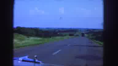 Denver Colorado (1958): Drives A Car On A Paved Road In Front Of A Truck Woman In