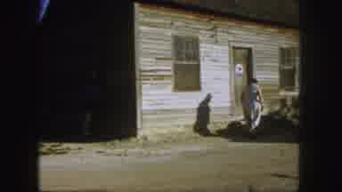 Denver Colorado (1958): Woman Wearing White Dress Walks To Door Of Wooden Brown
