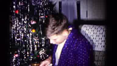 Hagerstown Maryland USA (1958): Young Boy Unwraps Gift While Sitting Next To The