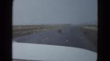 Las Vegas USA (1958): Car Driving On The Road In The Desert While A Tumbleweed