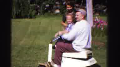 Ontario Canada (1958): Man And Boy Riding On A Small Motorized Vehicle Over Grass