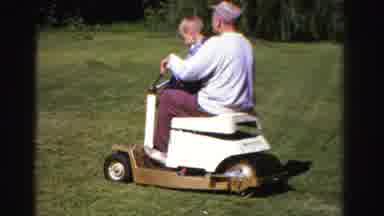 Ontario Canada (1958): A Small Boy Is Learning To Ride A Vehicle With The Help Of