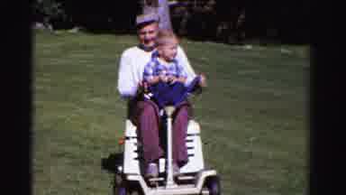 Ontario Canada (1958): A Man And A Boy Ride A Scooter Around In The Yard