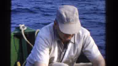 Ontario Canada (1958): Man Fishing In Small Boat Removing A Fish From His Line