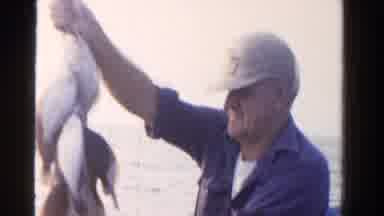 Ontario Canada (1958): Man Wearing Blue Shirt Holds Up Line Of Caught Fish On A