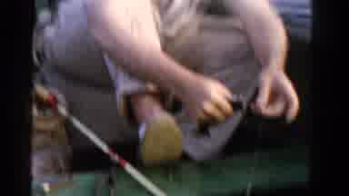 Ontario Canada (1958): Man Wearing Tan Shirt Unhooks Fish While Man Wearing Tan