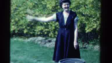 Ontario Canada (1958): Woman Wearing Black Dress Waves At Camera On A Sunny Day
