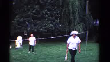 Ontario Canada (1958): People In White Playing Badminton On Sunny Day In Backyard