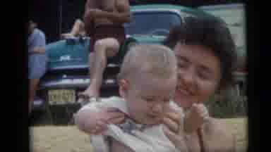 Camden New Jersey USA (1959): Beach Woman Holding Baby Smiling Man Sitting On Teal