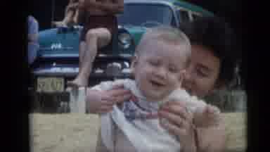 Camden New Jersey USA (1959): Woman Holds Baby Wearing White Shirt On A Clear Day