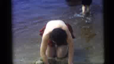 Camden New Jersey USA (1959): Woman Digging In Sand At Shoreline Cuts To Man