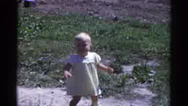 Catskill New York USA (1959): A Little Baby Girl In A Dress Attempting To Stand Up