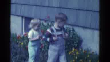 Catskill New York USA (1959): Caucasian Boy And Girl Walk Outside Garden With Red