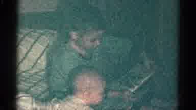 Catskill New York USA (1959): Child Reading Story To Baby Lying On Tummy On Bed In