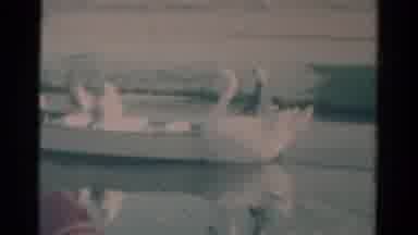 Catskill New York USA-1959: Swan Boat Sails Through Water As Cartoon Characters Walk
