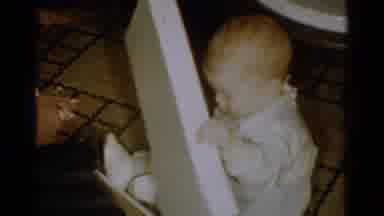 Catskill New York USA (1959): Baby On The Floor Grabbing The Cover Of A Box And A