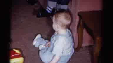Catskill New York USA (1959): Baby Wearing Blue Overalls Crawls Away From Red And