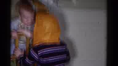 Catskill New York USA (1959): Child Wearing Orange Clown Mask Walks Towards