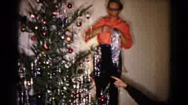 HAGERSTOWN MARYLAND USA-1959: Man Decorates Christmas Tree With Tinsel And Ornaments