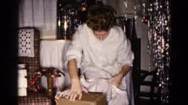 Hagerstown Maryland USA (1959): Woman Opening Up Christmas Present In Front Of