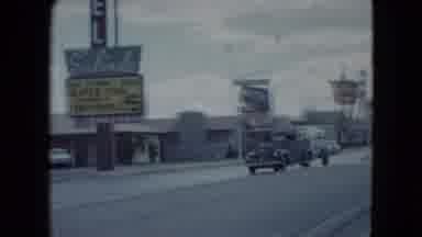 Nevada USA (1959): Driving Down The Road Past Antique Cars And Old Motels